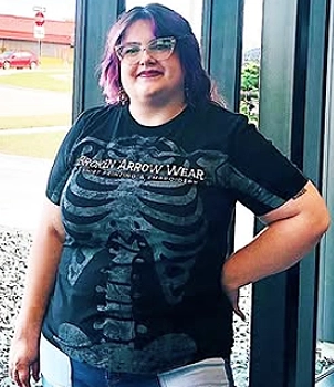 a photo of a model wearing an all over print front t-shirt with a skeleton on it.