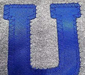 photo of blue tackle twill applique material on a grey sweatshirt