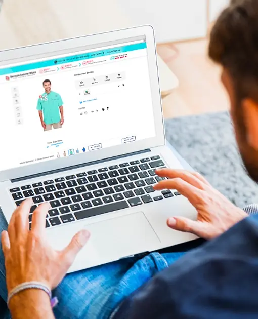a photo of a person on a laptop creating a custom design on a sea colored fishing shirt