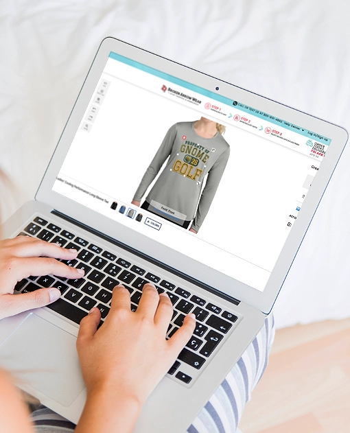 a photo of a person on a laptop designing a women's long sleeve t-shirt in the BrokenArrowWear online design studio