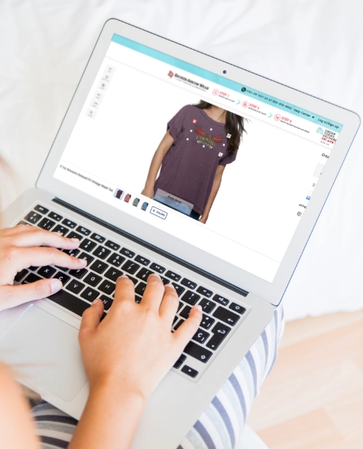 a photo of a person on a laptop designing a women's relaxed fit t-shirt in the BrokenArrowWear online design studio