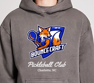 Custom gray hoodie with Bouncecraft Pickleball Club logo, featuring an illustrated fox mascot holding a paddle.