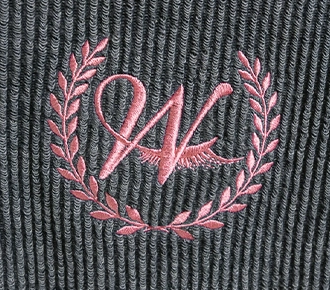a photo of a pink embroidered design on a corded sweatshirt