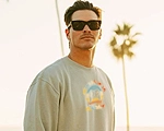 photo of a man outside wearing a crewneck sweatshirt and sunglasses