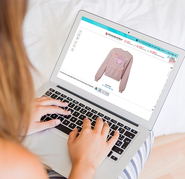 a photo of a person on a laptop designing a carhartt hoodie in the BrokenArrowWear online design studio