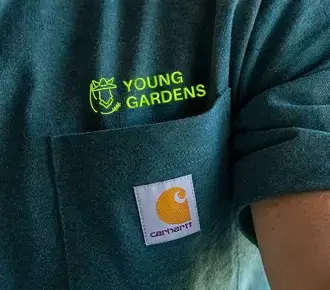 Custom logo printed above the pocket on a green Carhartt t-shirt for Young Gardens.