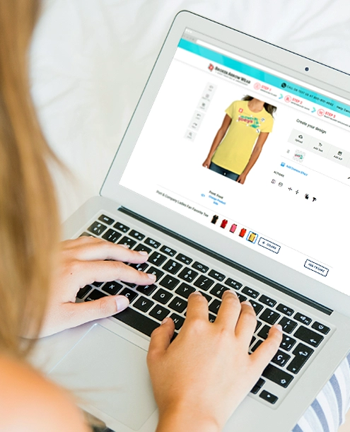 a photo of a person on a laptop designing a custom women's shirt in the BrokenArrowWear online design studio