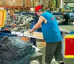 man wearing blue shirt on a screen printing press