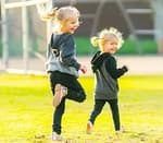 two kids in a field wearing hoodies