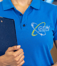 Close-up of a blue uniform polo shirt featuring a custom rhinestone logo for GEN with a yellow orbital graphic on the chest.