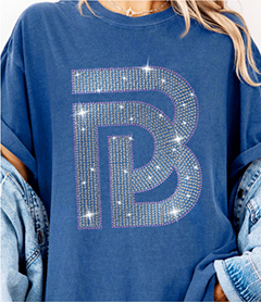 Large interlocking B initial logo in clear rhinestone fill on a royal blue t-shirt.