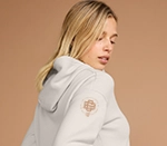 woman wearing a white hooded sweatshirt with a custom design on the sleeve