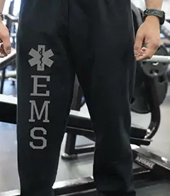 Black athletic sweatpants with EMS and a Star of Life symbol printed vertically down the leg.